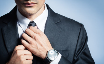 Man in a suit fixing his tie.